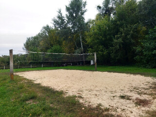 Volleyball court surrounded by trees in a quiet park area