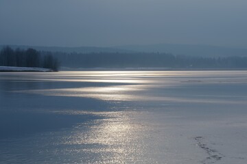 Frozen lake surface reflecting winter sunlight creating calm scene