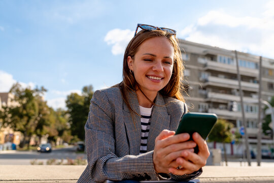 Urban woman checking her smartphone outdoors in city