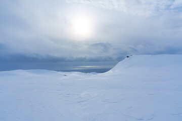 White glacier mountain with snowmobile track on summit in winter