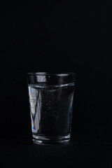 Minimalist Glass of Water with Bubbles on Black