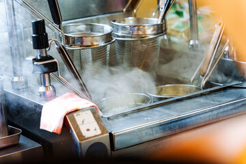 Hot steaming ramen noodle cooking with stainless kitchen equipment