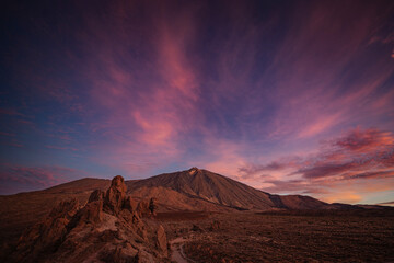 Vibrant sunset sky over Mount Teide in Tenerife, Canary Islands. Dramatic colorful clouds illuminate the volcanic landscape during the golden hour. A stunning scene capturing the beauty of Teide