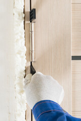 Removing the mounting wedges when installing the door, close-up