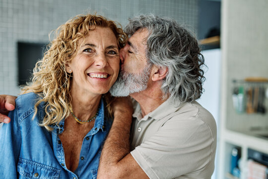 Portrait of happy senior mid aged mature couple prepering meal with fresh vegatebles in kitchen at hpme - Powered by Adobe