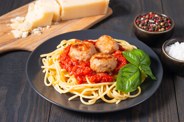 Delicious spaghetti with tasty meatballs in tomato sauce, and basil on background. Restaurant menu.