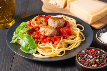 Delicious spaghetti with tasty meatballs in tomato sauce, and basil on background. Restaurant menu.