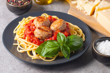 Delicious spaghetti with tasty meatballs in tomato sauce, and basil on background. Restaurant menu.