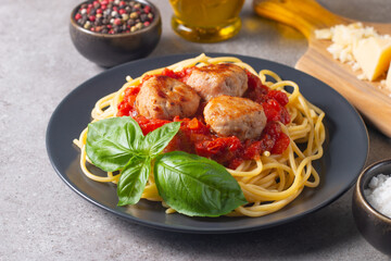 Delicious spaghetti with tasty meatballs in tomato sauce, and basil on background. Restaurant menu.