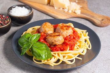 Delicious spaghetti with tasty meatballs in tomato sauce, and basil on background. Restaurant menu.