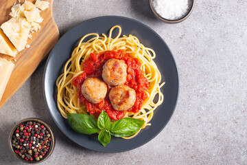 Delicious spaghetti with tasty meatballs in tomato sauce, and basil on background. Restaurant menu.