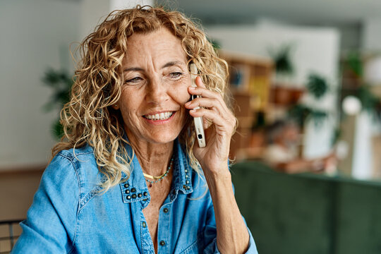 Portrait of a mature senior woman or a  businesswoman working from home having a meeting online, home office, or a student learning, or mature woman having a phone call, holding a mobile phone, smartp