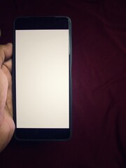 Hand holding smartphone on gray