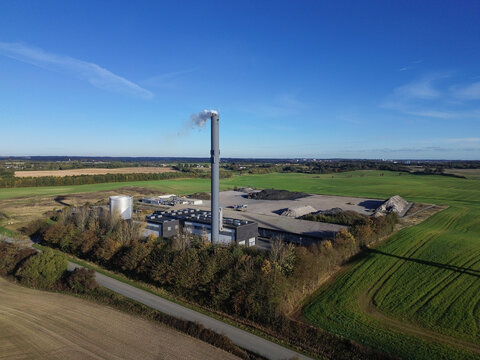 Heating plant and wind turbines in Southern Denmark. Rural contrast between fossil energy and green power in scenic landscape - Powered by Adobe