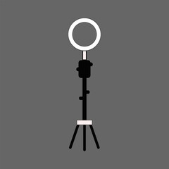 A simple black silhouette of a ring light with a tripod stand on a gray background silhouette
