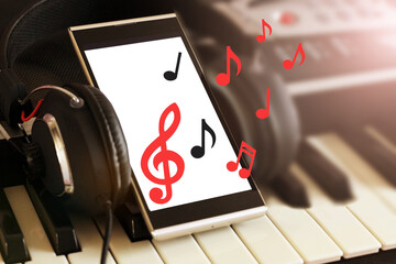 Headphones and a smartphone with an image of notes.