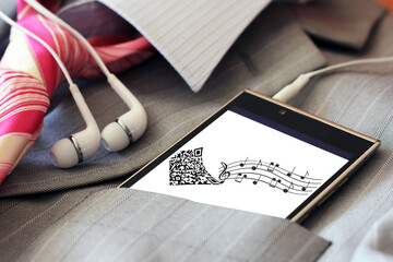 Headphones and a smartphone with an image of notes.