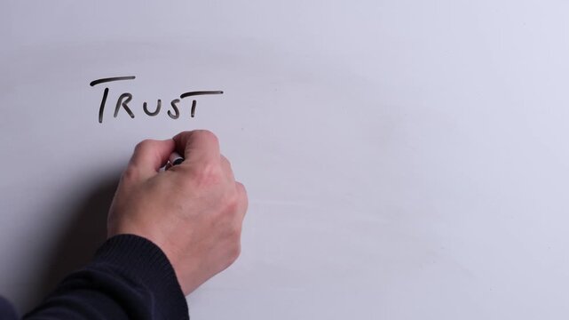A person is writing Trust His Word in black marker pen on a whiteboard, perfect for Christian, religious themes, Church communications or faith presentations
