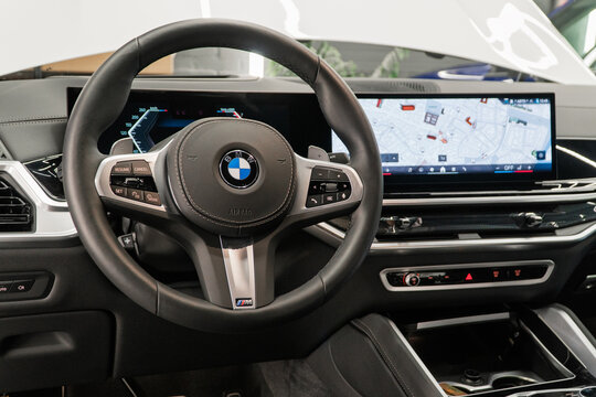 BMW X6 G06 xDrive 40i M Sport steering wheel, dashboard, gear shifting. Black leather car modern interior of the BMW X6 G06 40i M Sport. Vehicle interior German premium SUV car. 