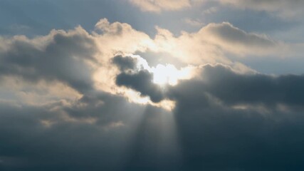 Sunbeams breaking through dramatic clouds, creating a sense of hope and awe in the sky
