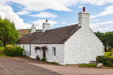Traditional whitewashed stone cottage in Scottish countryside