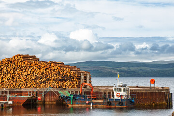 Timber pile and workboat at coastal dock in Scotland