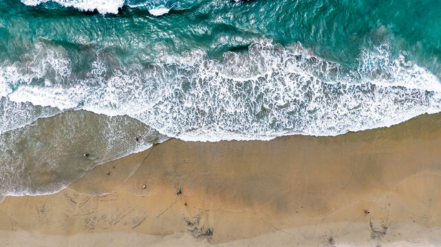 Aerial nature top down ocean waves on the beach southern Del Mar San Diego California CA