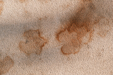 Maple leaf print on concrete pavement, brown leaf mark on light stone surface in city park, autumn season detail, close-up texture.