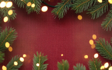 Christmas background with xmas tree and sparkle bokeh lights on red canvas background. Merry christmas card. Winter holiday theme. Happy New Year. Space for text 
