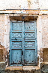 Old wooden door painted in blue, in an abandoned house. 