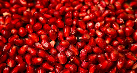 Juicy pomegranate seeds texture. Food ingredient background top view