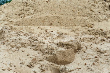 Sand pile at construction site during afternoon sunlight showcasing texture and earthy tones