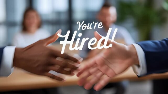 Firm handshake represents successful job offer between two professionals. Bright office setting with a team celebrating in the background. Concept of recruitment, business success, teamwork