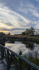 Boardwalk by the calm water reflecting cloudy sunset sky