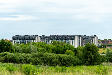 Modern residential buildings surrounded by lush greenery in a quiet neighborhood near a waterway