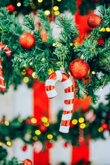 A beautifully decorated Christmas tree adorned with red glittery baubles and candy cane ornaments.