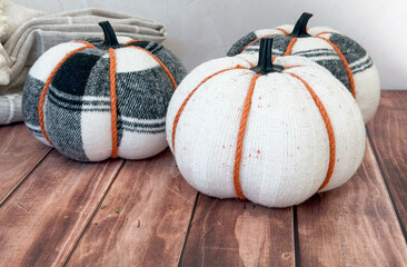 Cozy autumn decor with sweater pumpkins on rustic wooden floor—home decor shops, diy craft stores, seasonal event planners concept of
