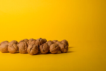 Nueces naturales sobre fondo amarillo. imagen ideal para temas de alimentación saludable, cocina natural o productos ecológicos.	