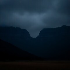 Fototapeta premium dark mountain range under cloudy sky