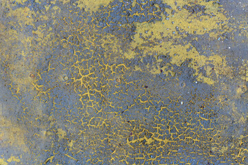 A close-up of an old metal surface with faded and cracked paint. The green underlayer and nail heads are visible. Background. Texture.
