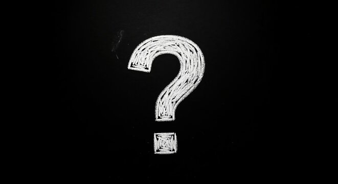 A question mark drawn with white chalk on a black chalkboard. Symbol of uncertainty, inquiry, and problems with copy space