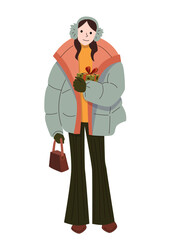 Smiling woman in winter outfit holding holiday gift box and handbag wearing earmuffs puffer jacket gloves and flared pants in cozy seasonal style