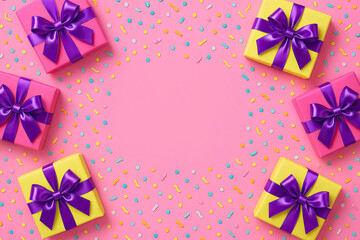 Bright gift boxes with purple bows and confetti on pink background