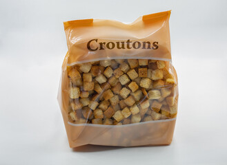 Bag of crunchy croutons closeup on white background.