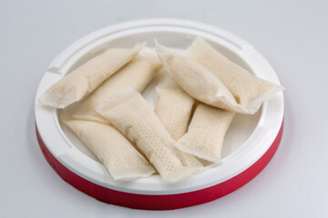 Nicotine pouches red container closeup on white.