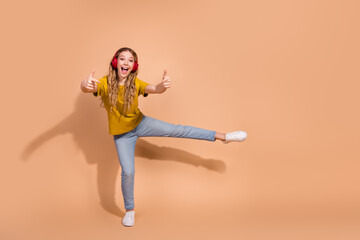 Energetic youth dancing with headphones on a beige background, expressing joy and positivity while...