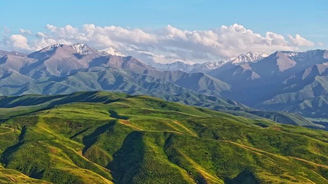 Majestic mountains and rolling hills under serene sky in Kyrgyzstan, drone hyper lapse with forward movement.
