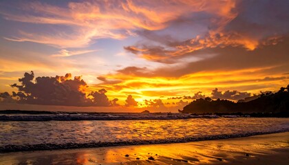 Naklejka premium Stunning beach sunset with fiery hues over the ocean and shoreline