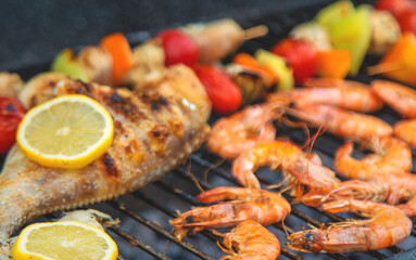 Shrimp, vegetables and fish are fried on a barbecue. Selective focus.