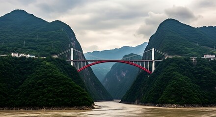 Majestic red arch bridge spanning a deep gorge between lush green mountains over a wide river